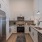 Stark white kitchen cabinets with stainless steel appliances.